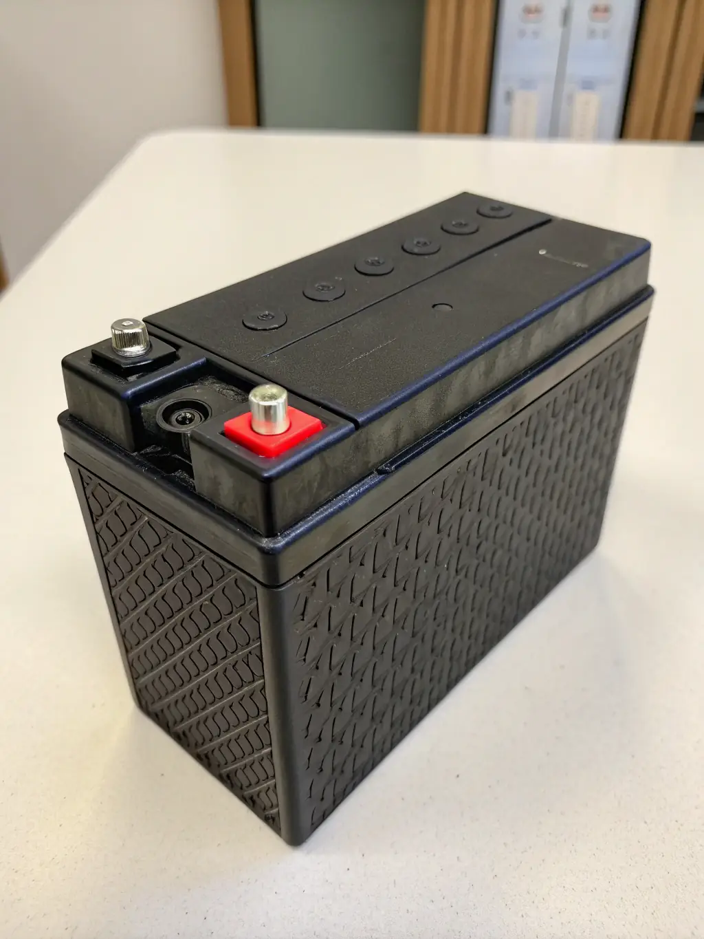 Detailed macro photograph of an e-bike battery pack, emphasizing its sleek design and advanced energy storage technology, placed on a clean, white surface.